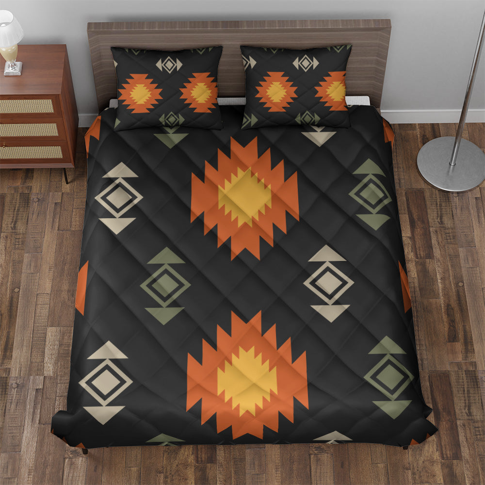 Black geometric quilt and two matching pillowcases with orange sunburst pattern