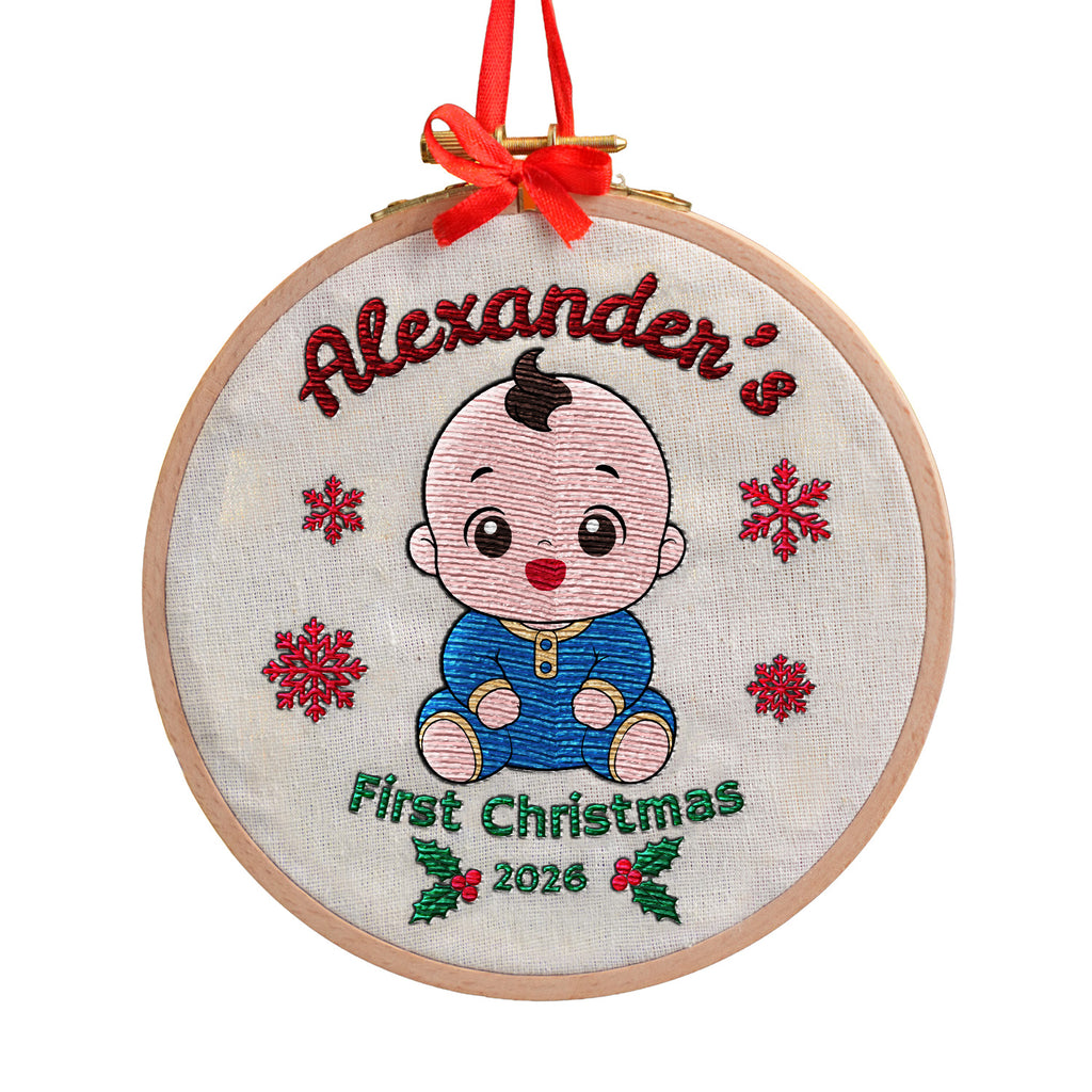 Personalized baby first Christmas embroidered hoop ornament showing smiling baby, red snowflakes and holly on white background