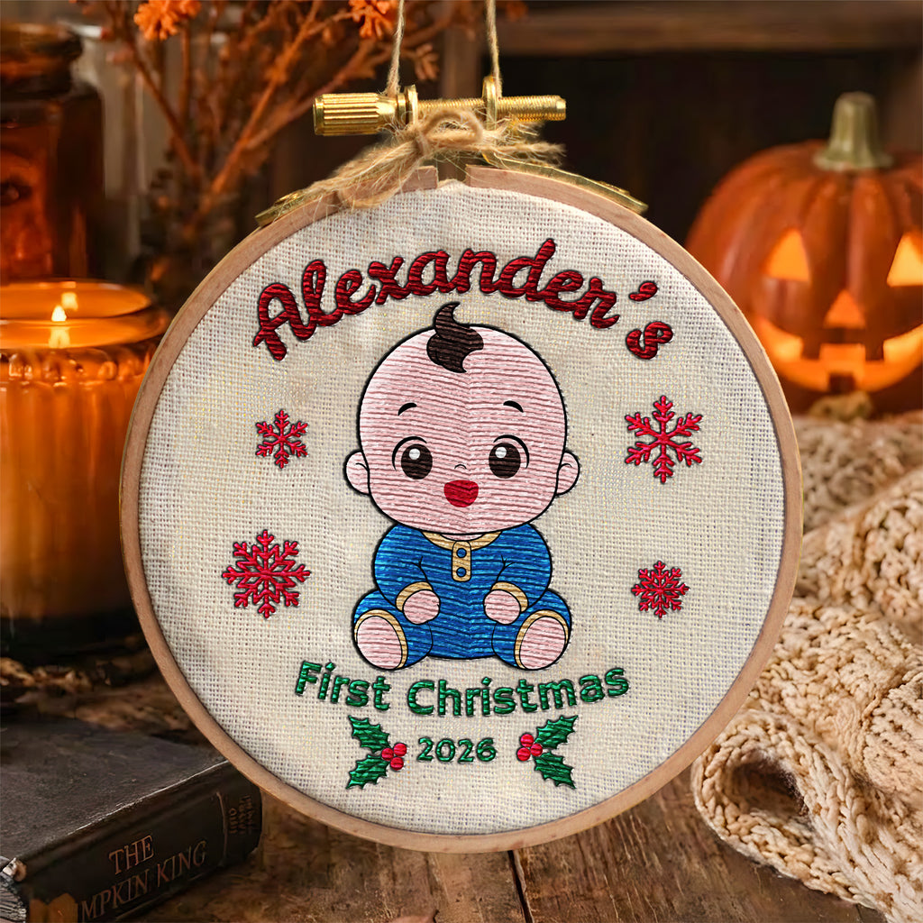 Personalized baby first Christmas embroidered hoop ornament showing smiling baby, red snowflakes and holly with natural jute hanger