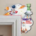 Single-layer personalized space astronaut wooden door name sign displayed on a white door