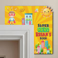 Single-layer personalized superhero wooden door name sign displayed on a white door