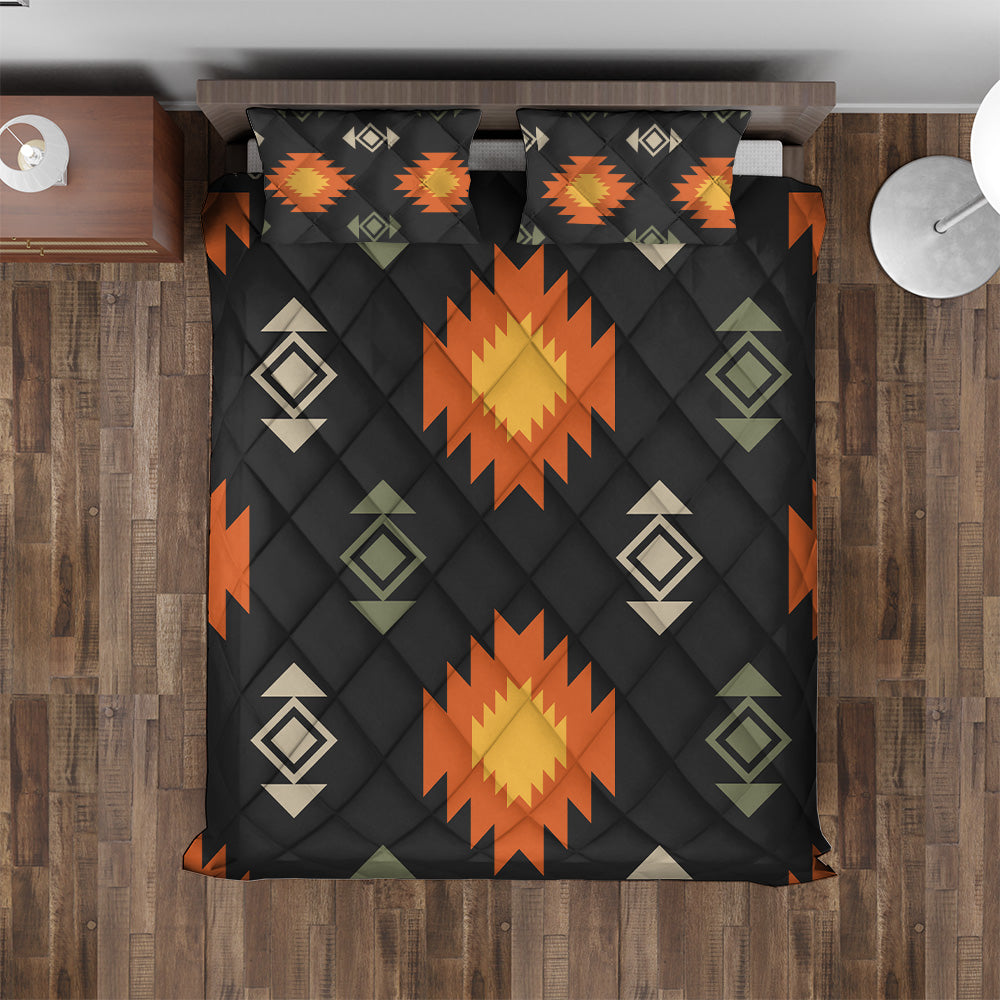 Overhead view of black Southwestern bedspread with orange geometric sunbursts