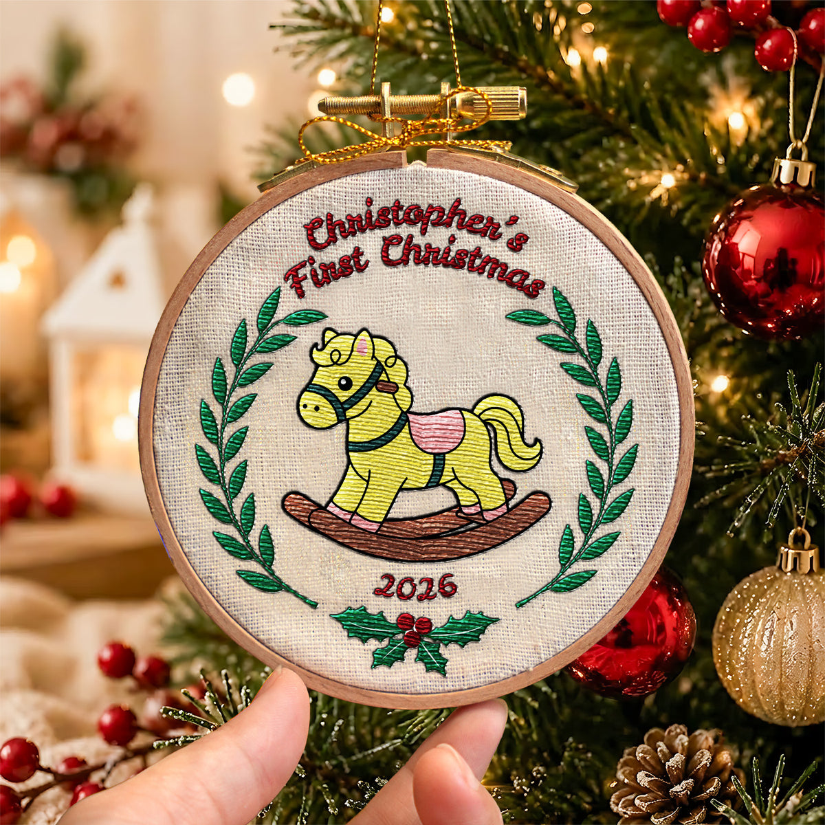 Personalized first Christmas embroidered hoop ornament featuring vintage rocking horse and green laurel wreath with gold ribbon hanger