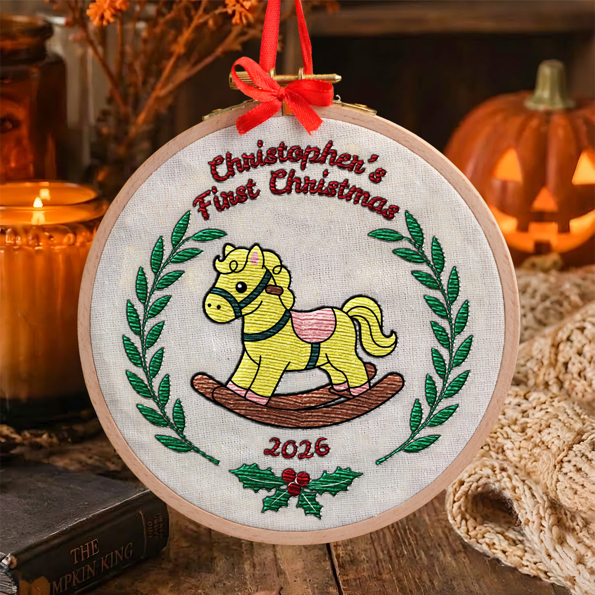 Personalized first Christmas embroidered hoop ornament featuring vintage rocking horse and green laurel wreath with red ribbon hanger